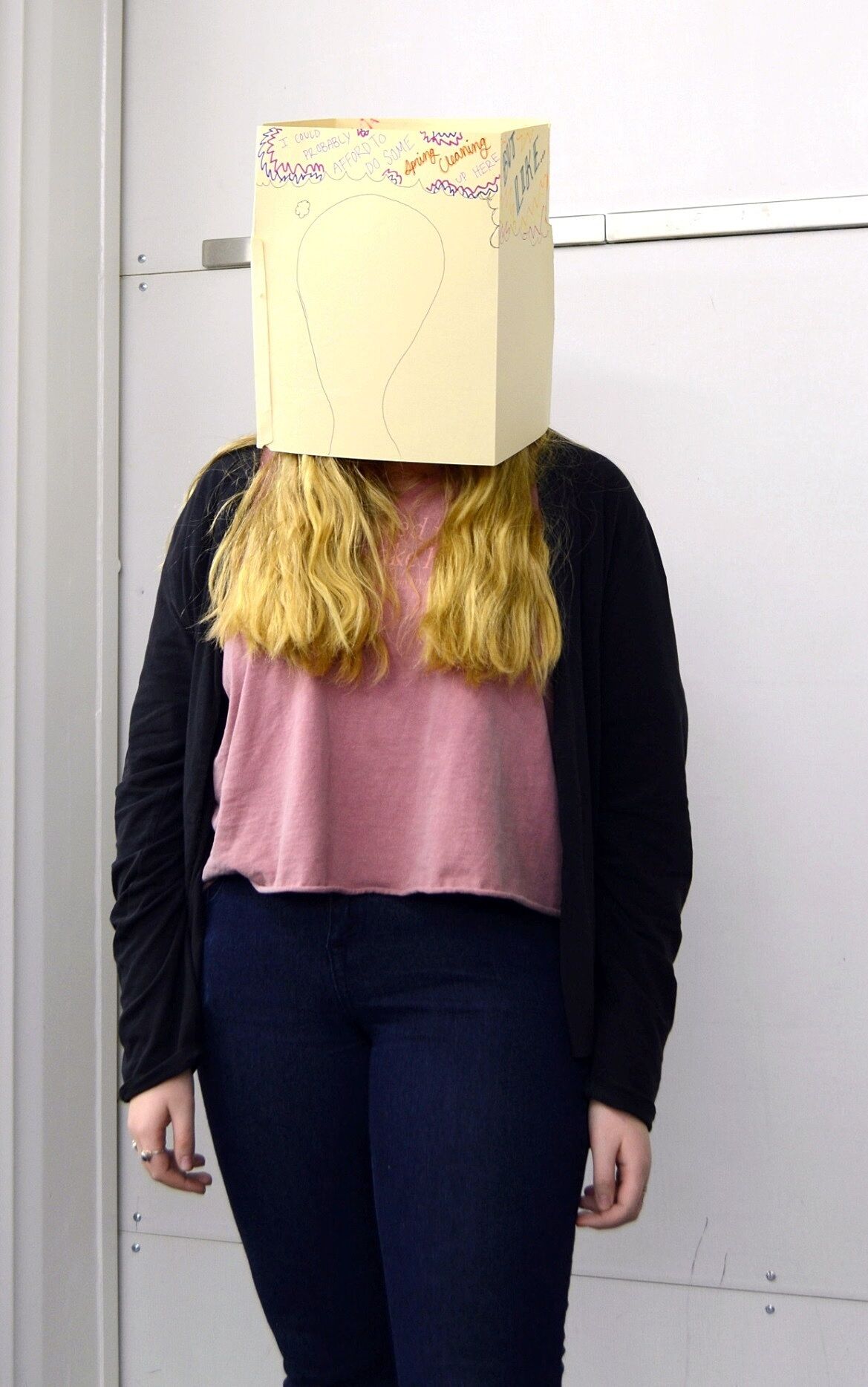A teen wears a bag on her head. 