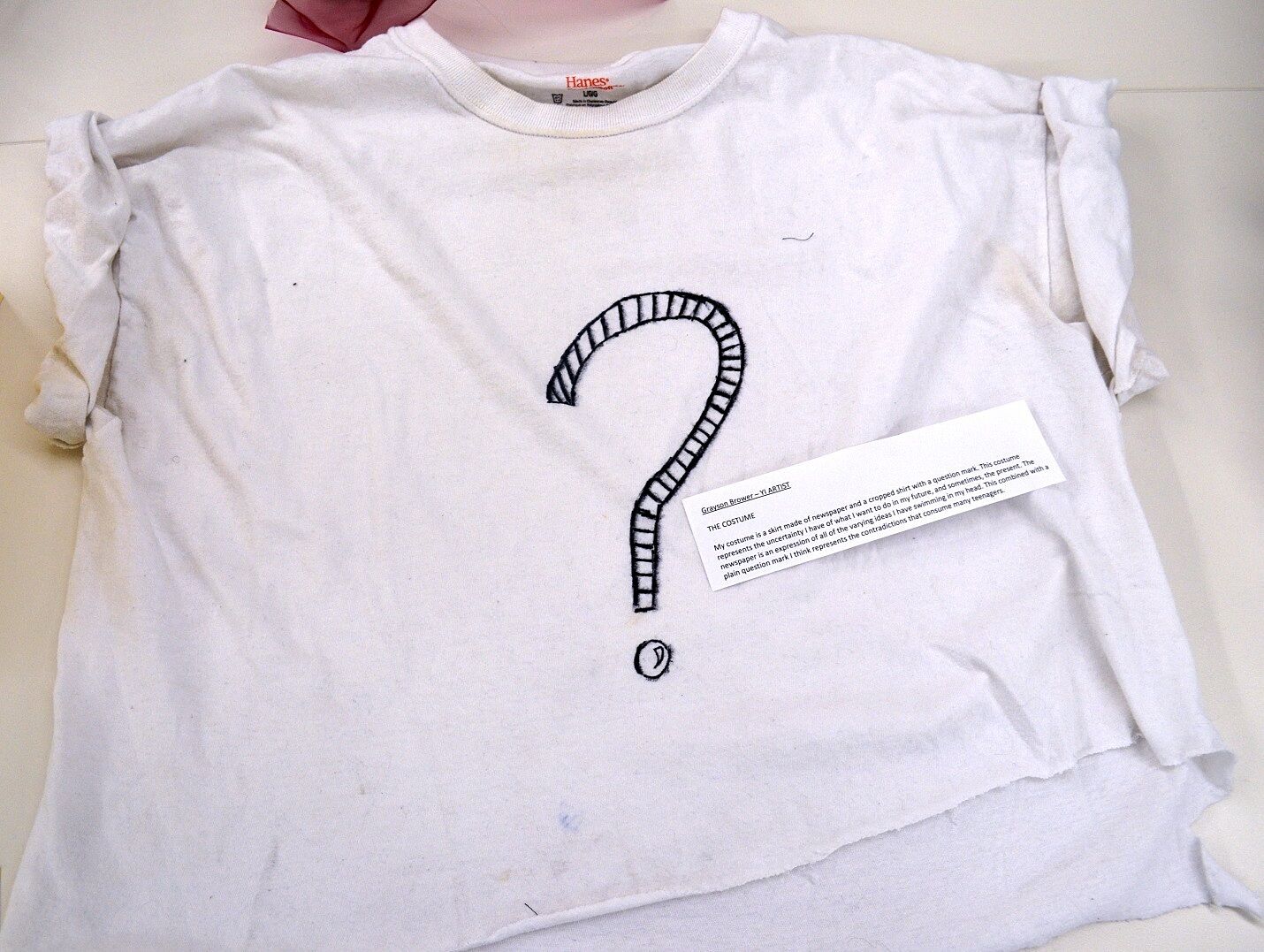 A white t-shirt with a question mark on it.