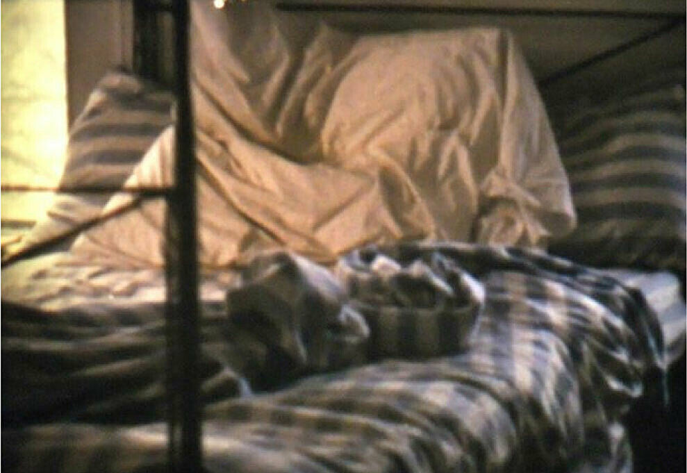 Unmade bed with blue checkered sheets
