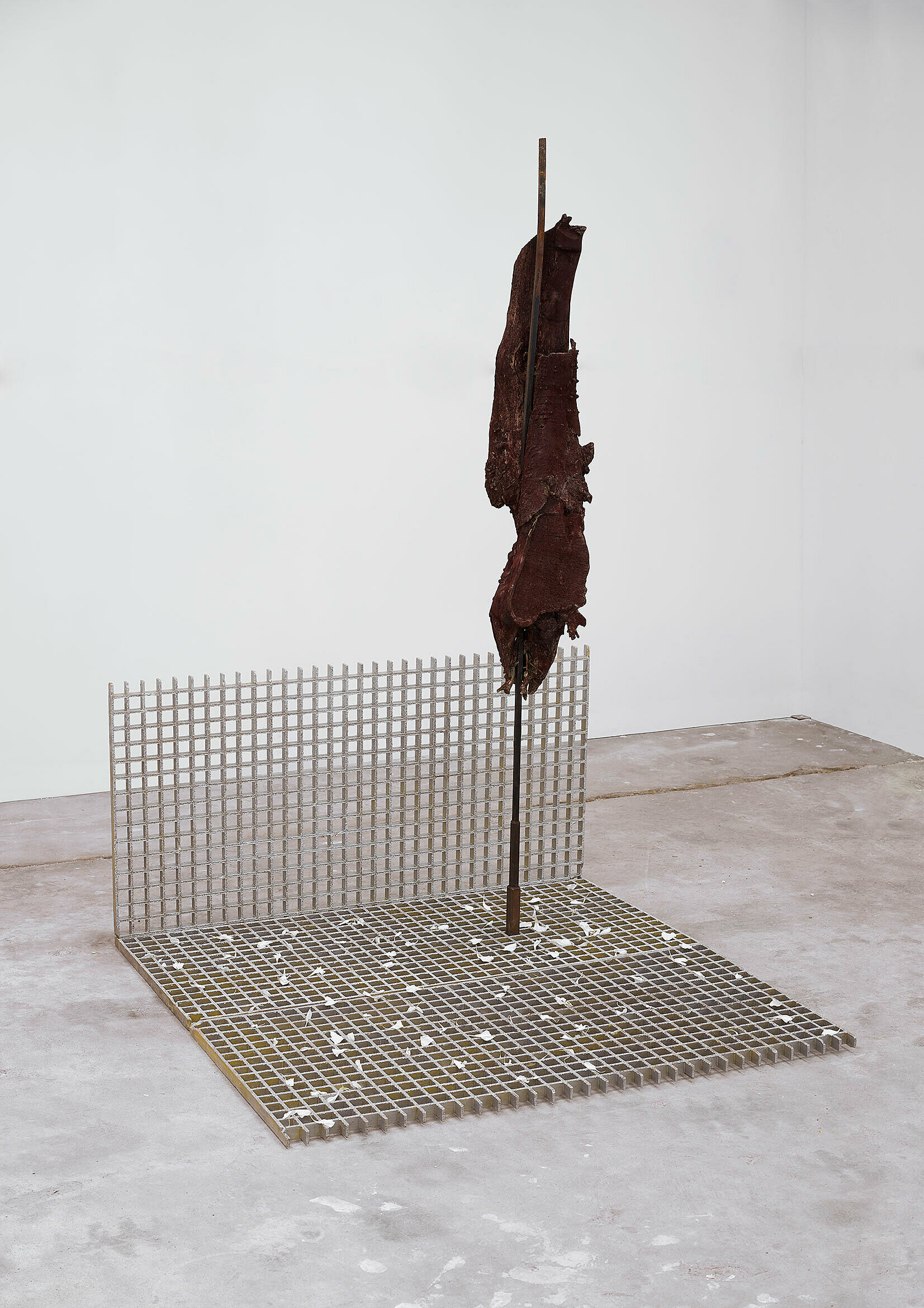 Piece of tree trunk on a wrought-iron bar in gridded base