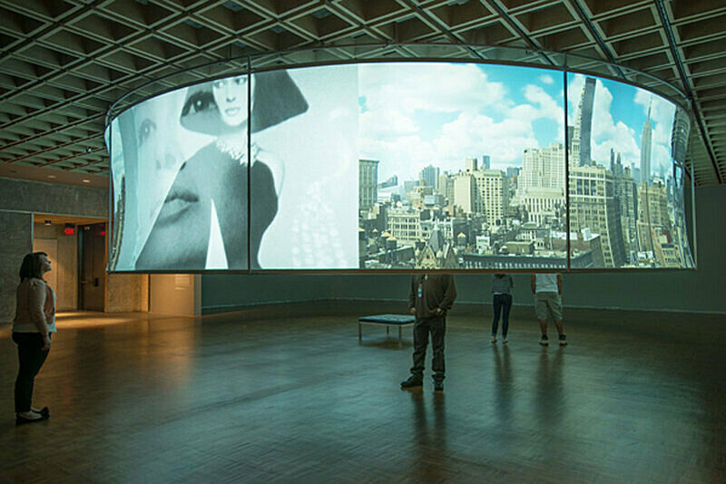 Projected panorama and woman's face on a large curved structure.