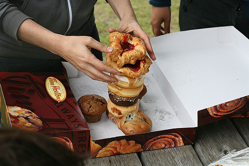 A sculpture made out of pastries standing in a cardboard box.