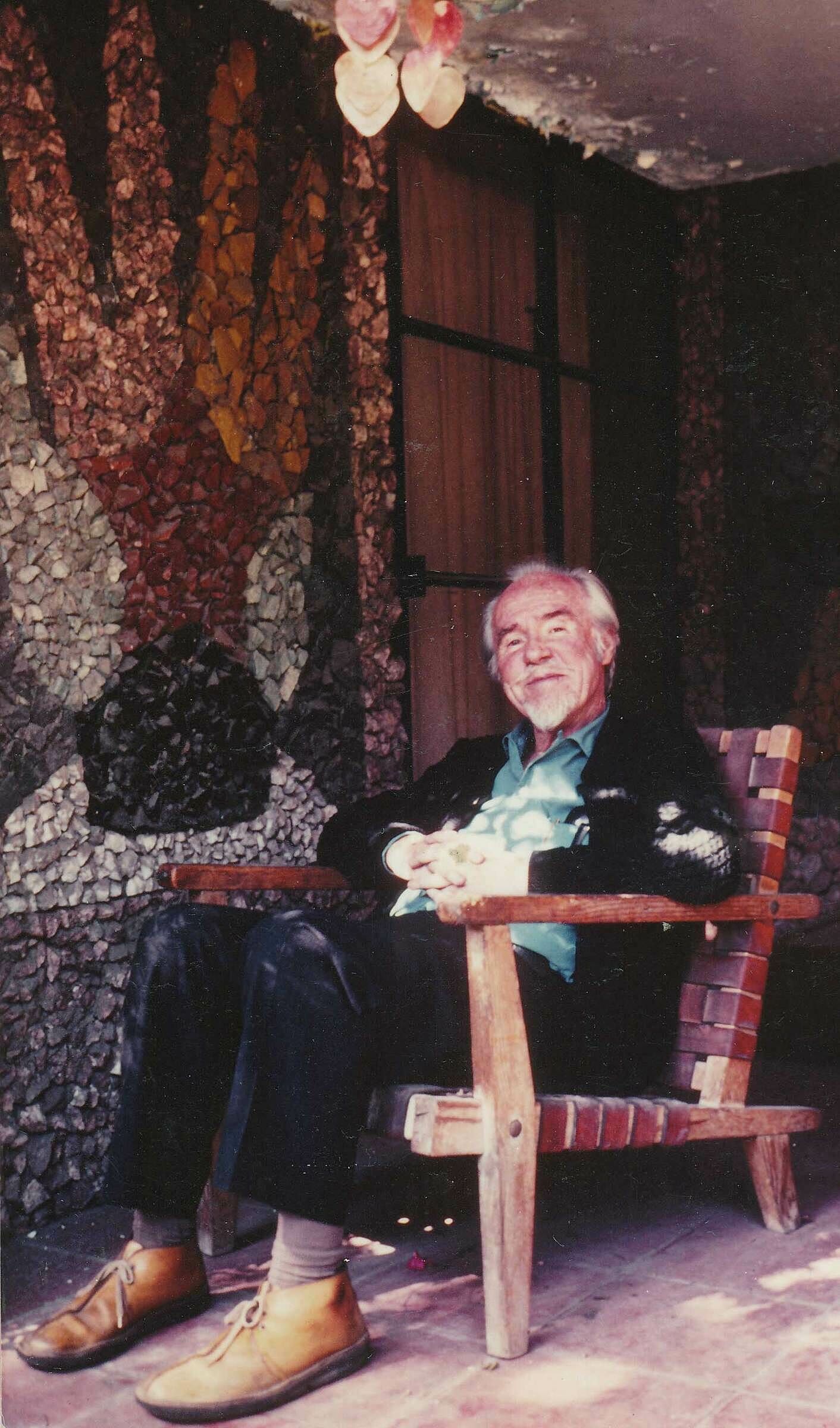 The composer Conlon Nancarrow  sits in a chair. 
