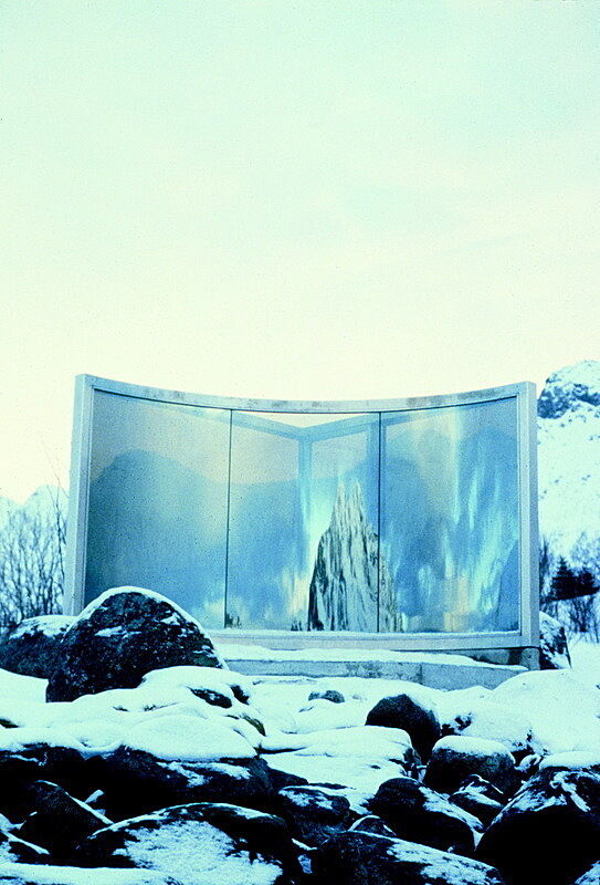 A tall wall of mirrors standing in the middle of a rocky landscape with snow.