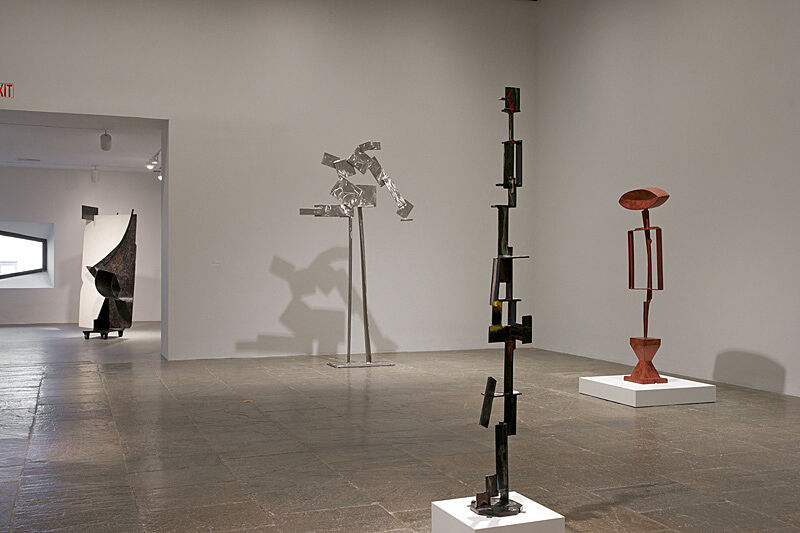 Sculptures by David Smith stand in a gallery.