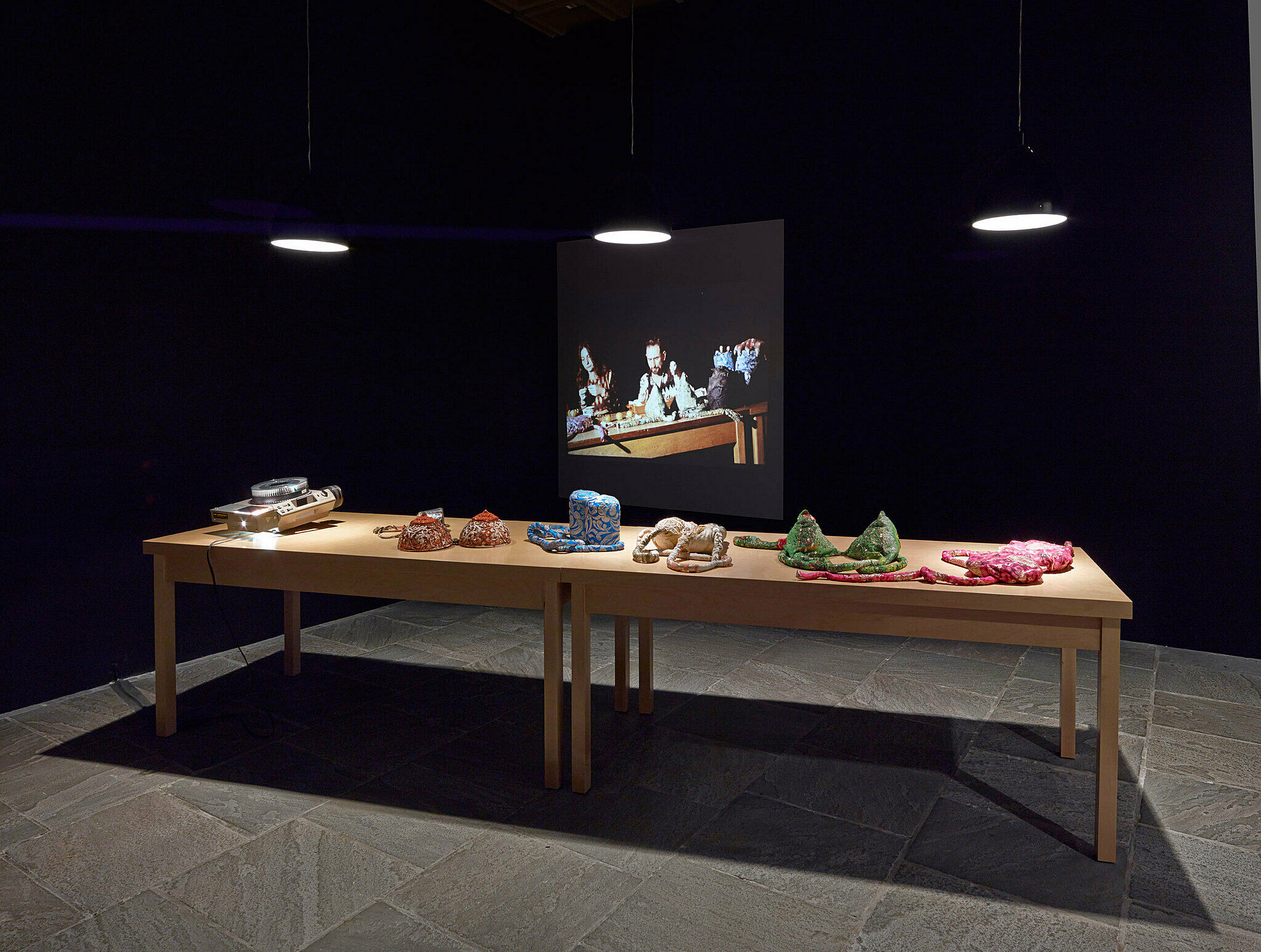 A table in front of a video still for an art installation.