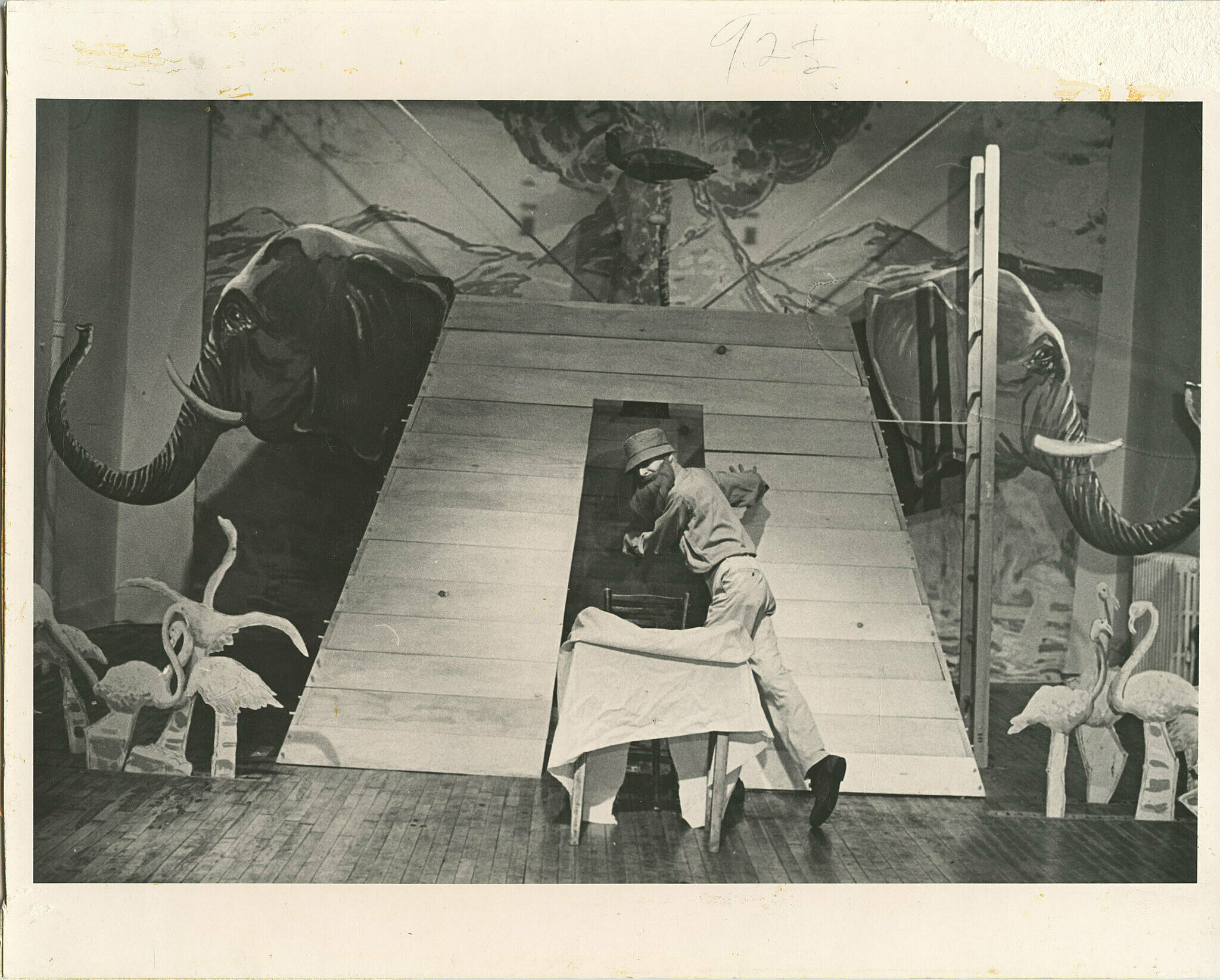 A stage with animal cutouts and a man walking through a door.