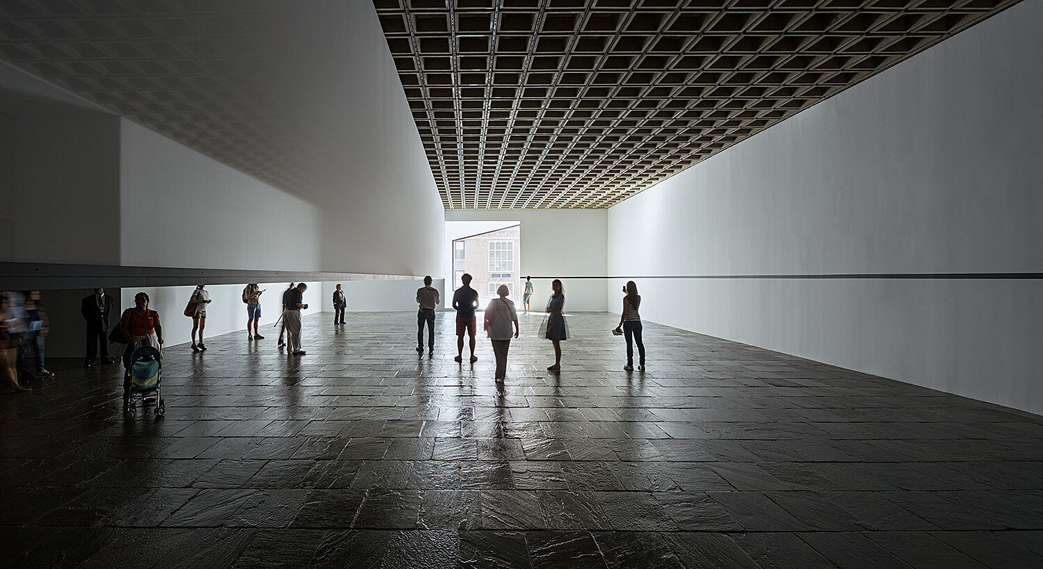 People standing in the middle of a darkened gallery.