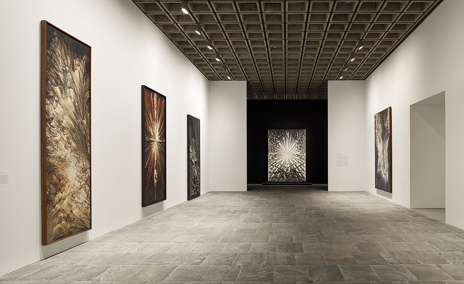 Large artworks housed in an illuminated gallery.