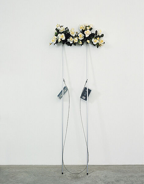 Two bouquets of flowers on a steel cable.