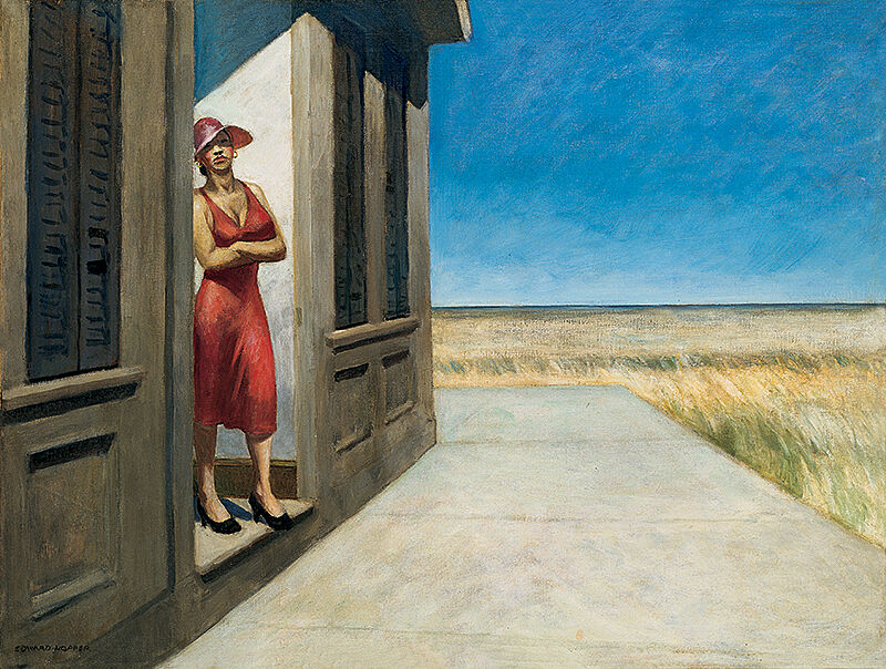 Woman in a hat looking out on a field.
