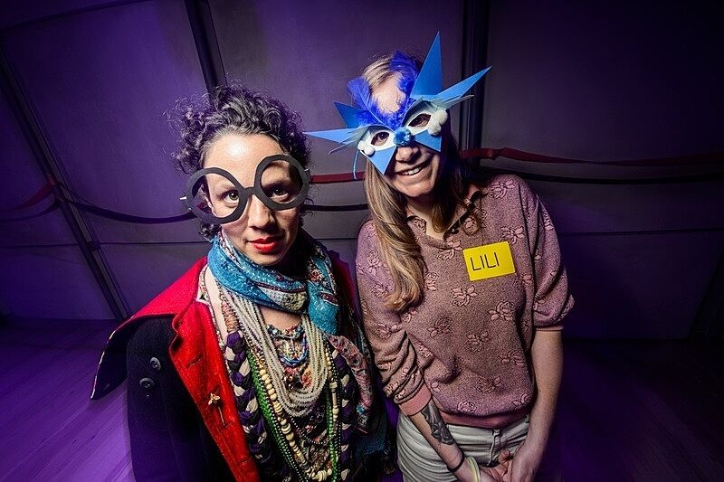 Two women in creative masks at a party.