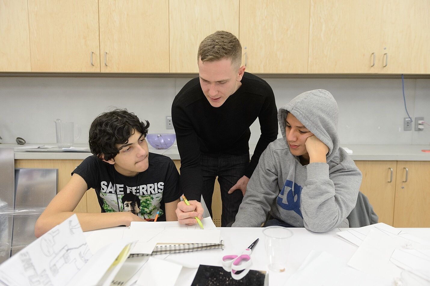 Artist working with two students.