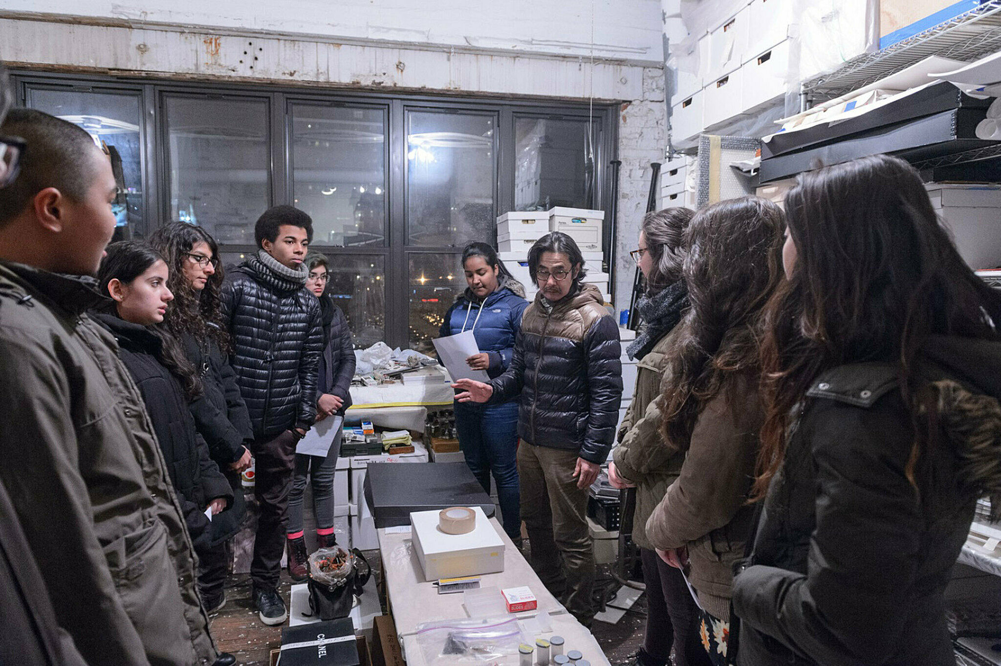 Group discusses artwork in a studio.
