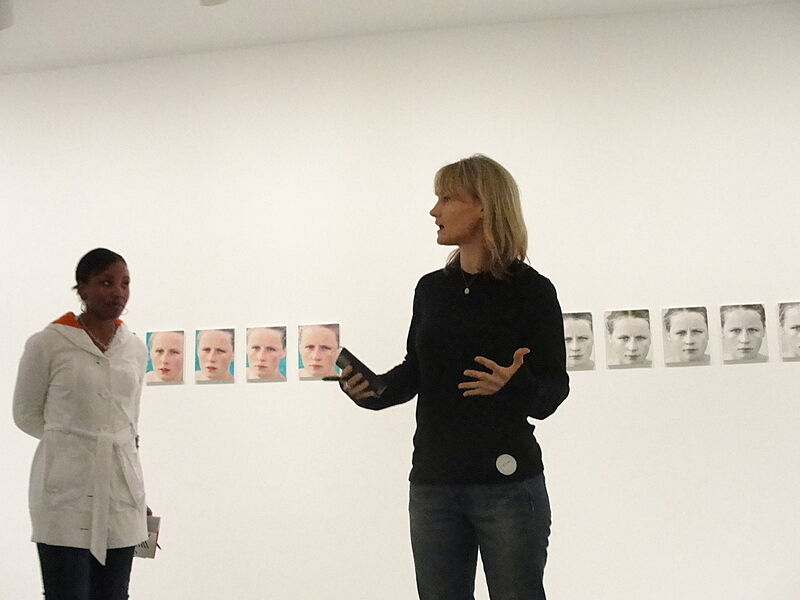 Artist talking to a student in a gallery.