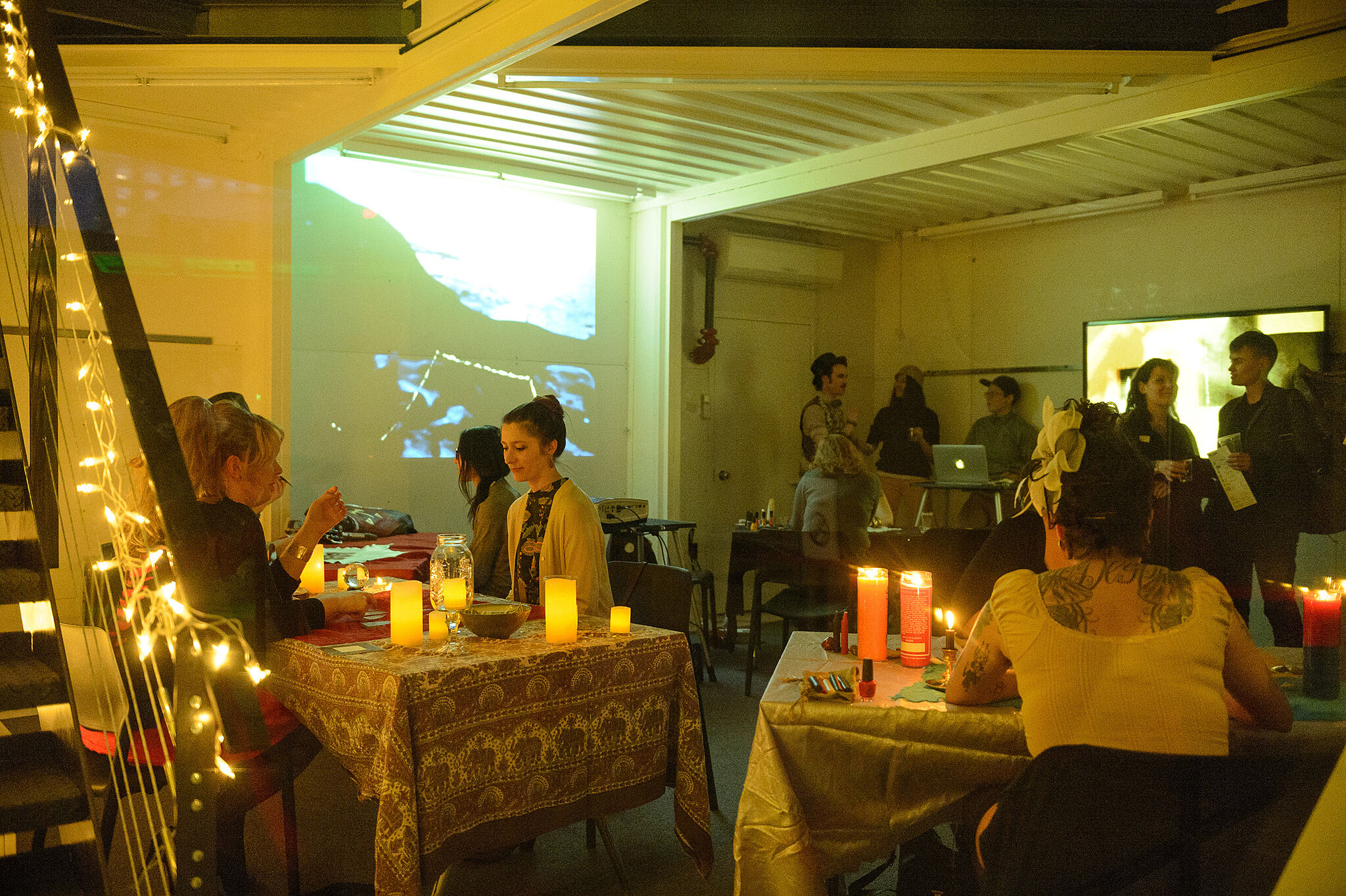 Museum guests sit down at tables with candles for fortune readings.
