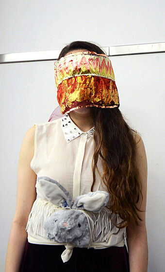 A teen wears a yellow and red mask. 