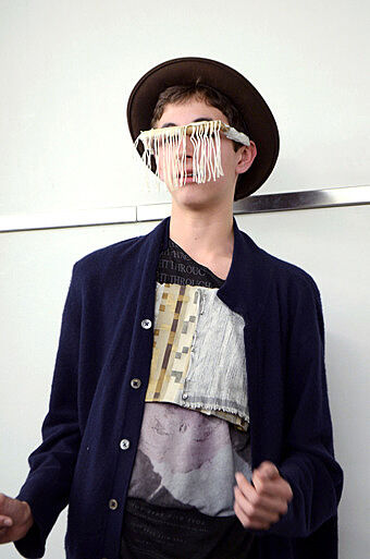 A teen artists wears glasses he made of fabric.