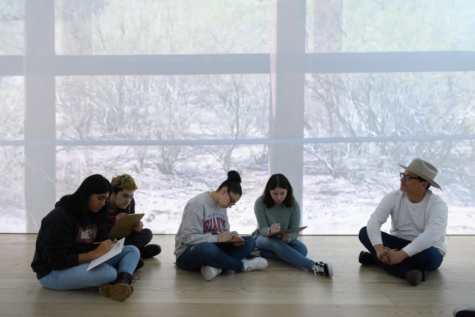 Kade L. Twist of artist collective Postcommodity leads a sketching activity in the group’s video installation A Very Long Line (2016).