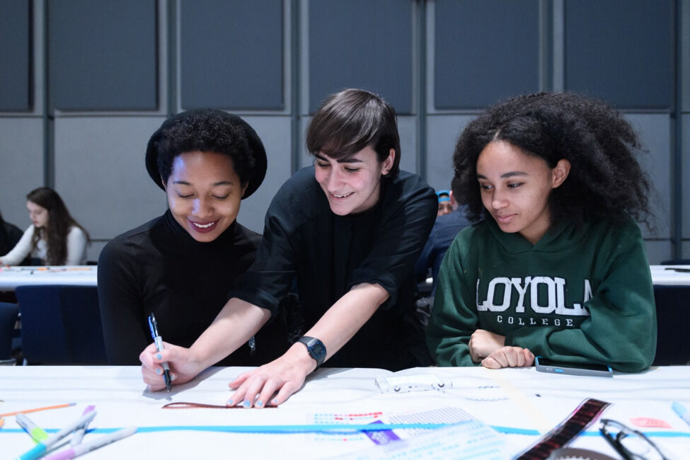 Three teens making art.