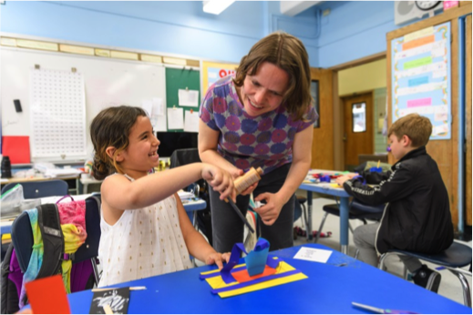 Whitney educator helps a student in the classroom
