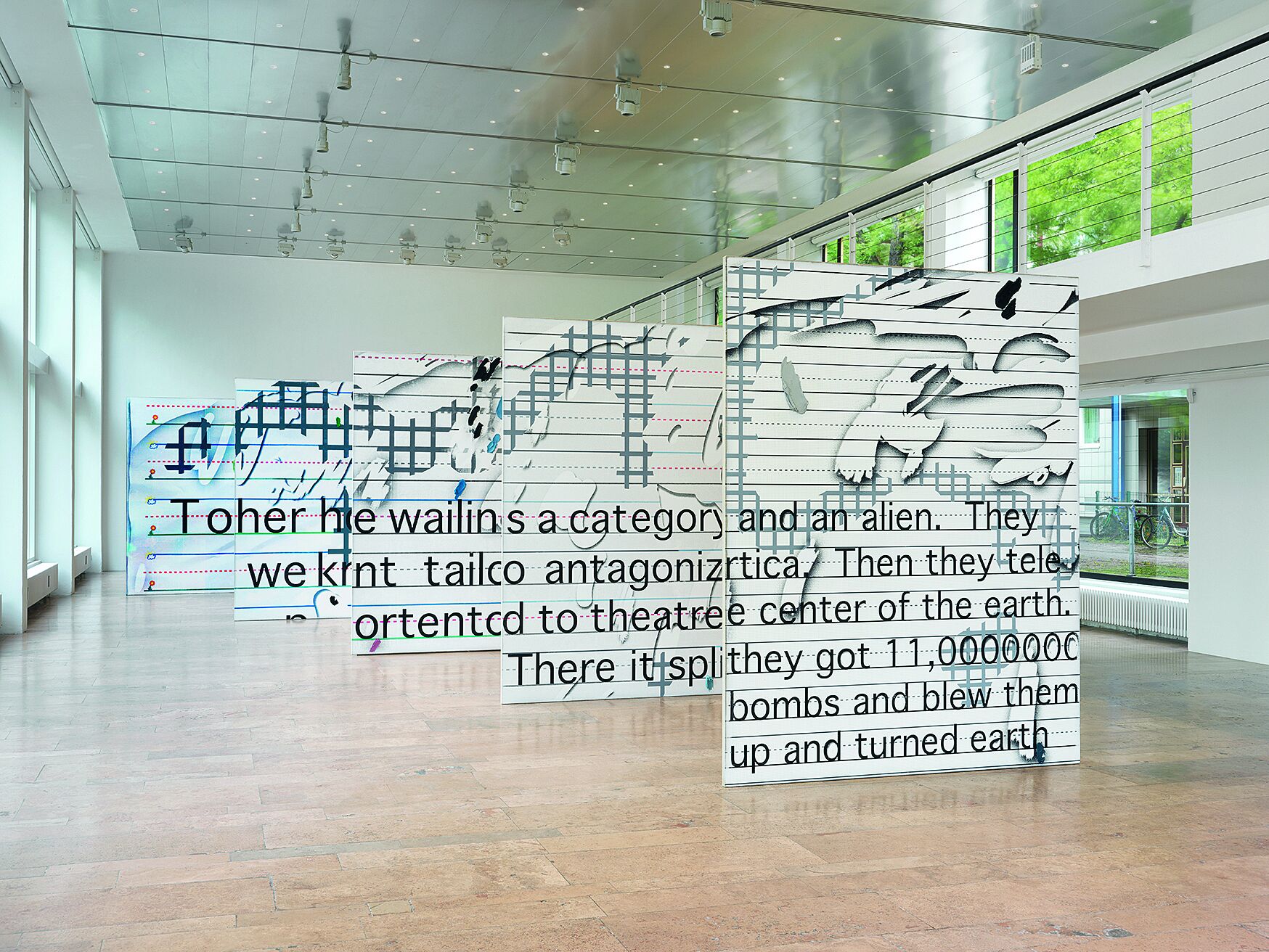 Multiple large canvasses with text arranged in a room.