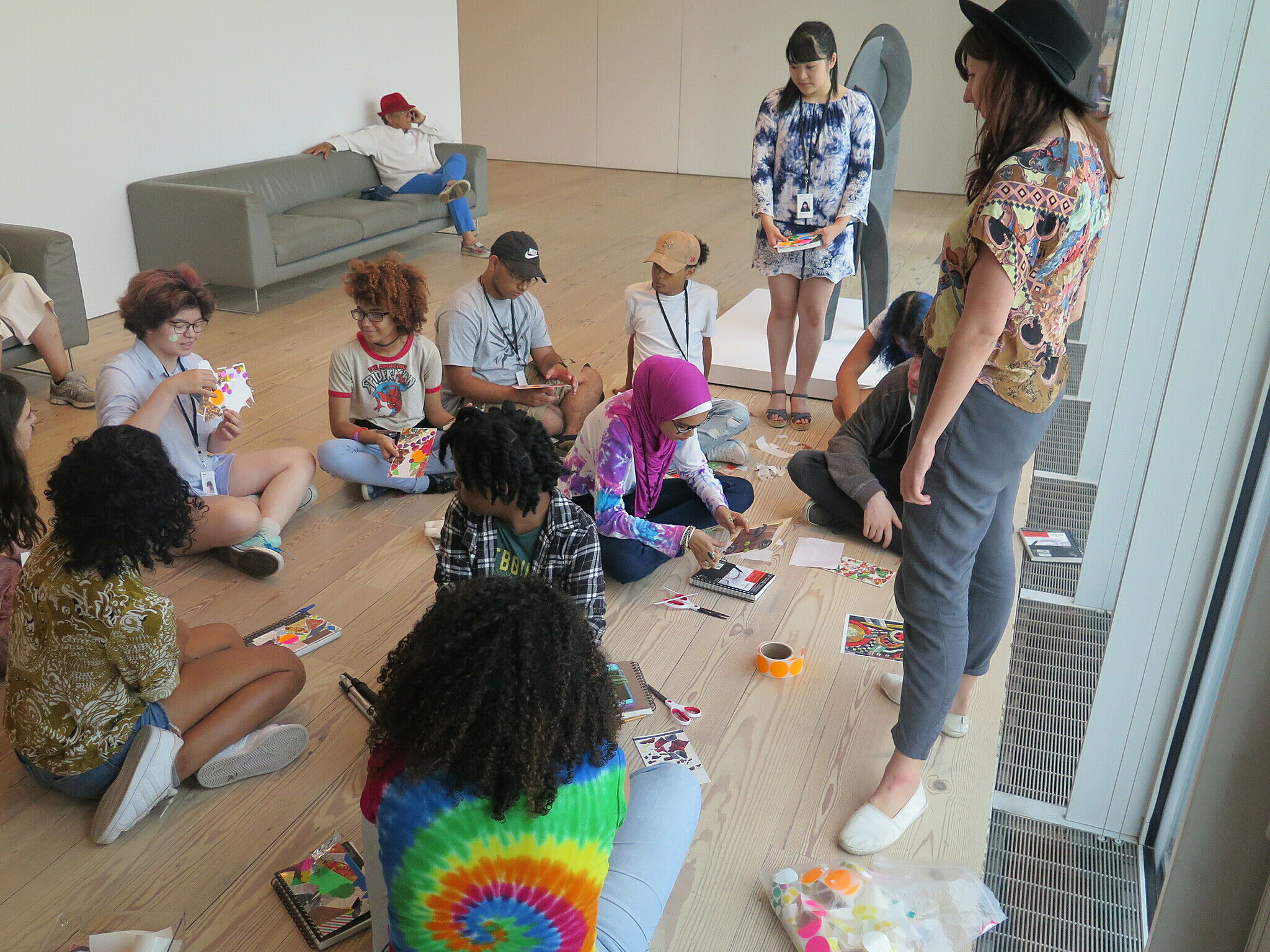 Billie Rae Vision standing and teens with art supplies sitting on the floor