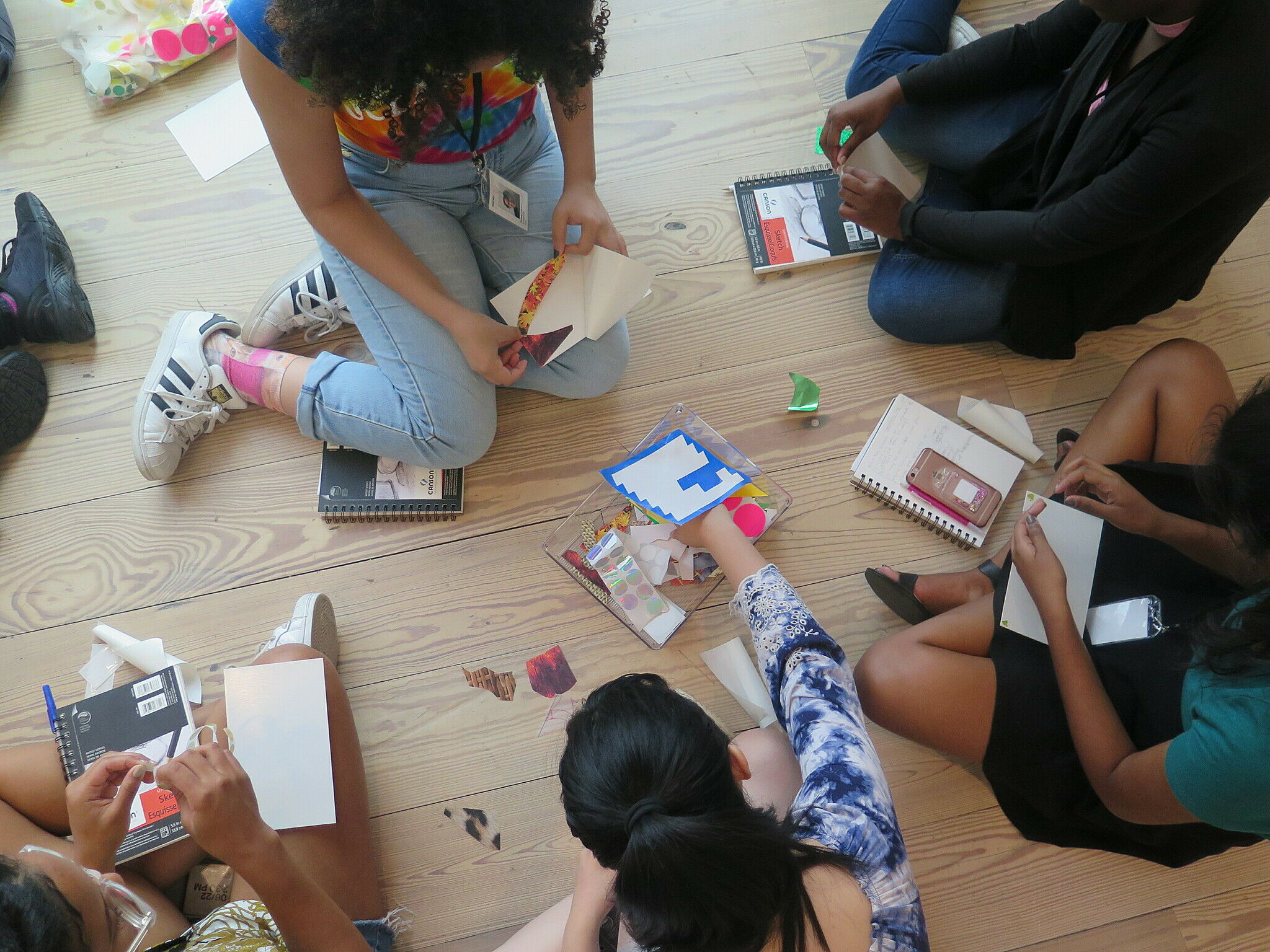 teens sitting on the floor with art supplies