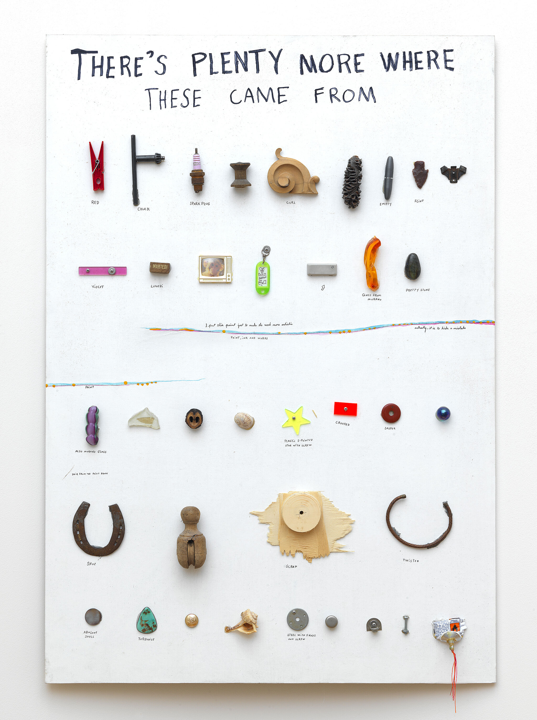 Objects from Jimmie Durham's studio on a white wood panel 