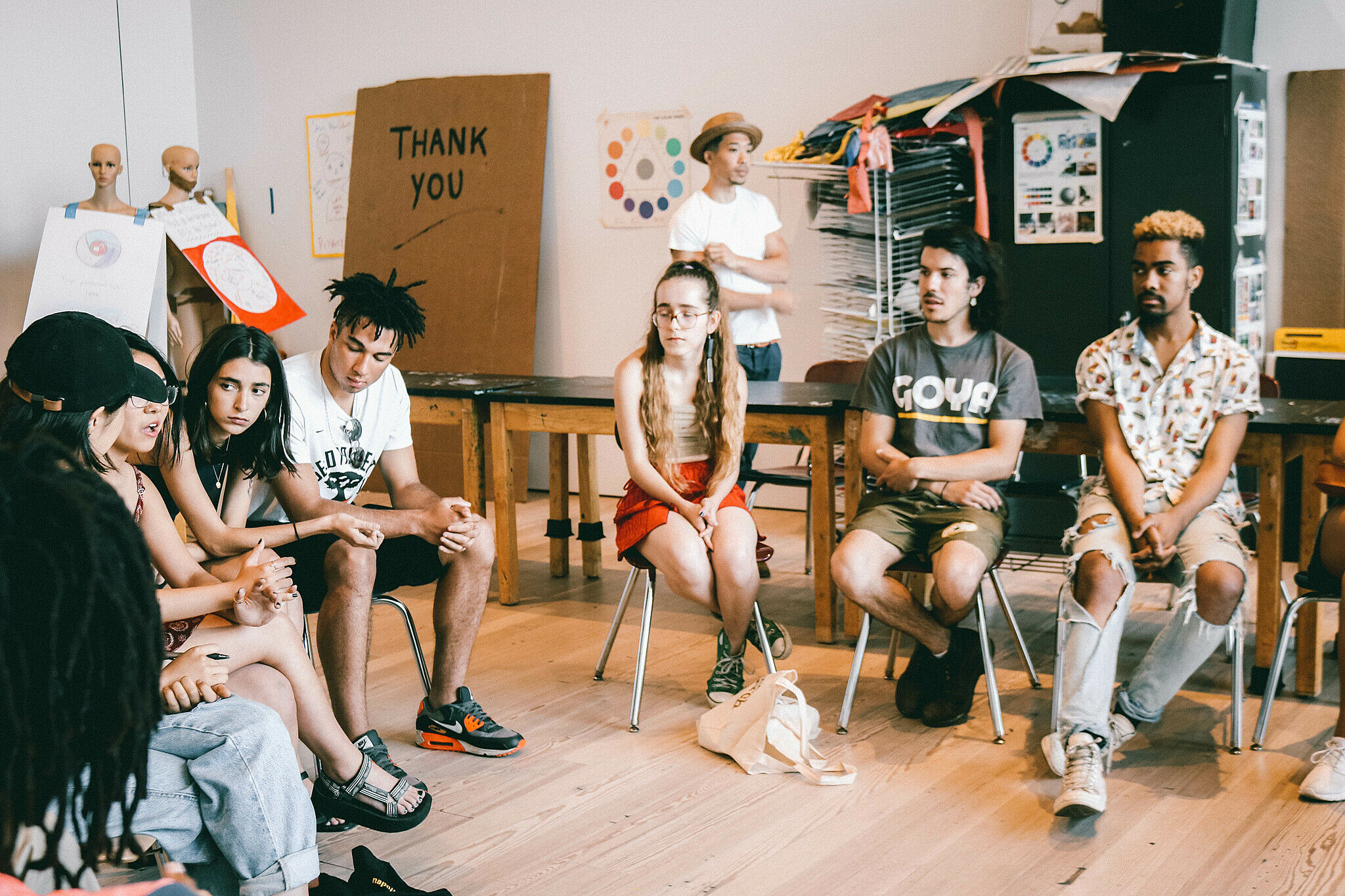 Group of teens sitting on chairs in a circle 