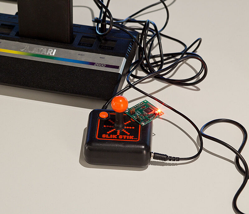 Installation view of Various Self Playing Bowling Games (aka Beat the Champ) by Cory Arcangel. Image depicts a close-up photograph of the vintage Atari game system "Slik Stick" controller.