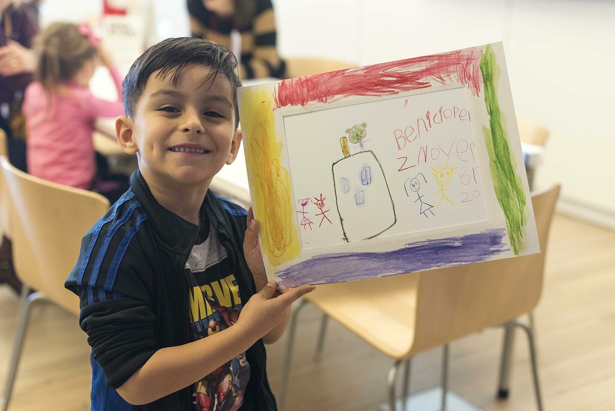 A kid showing off his artwork.