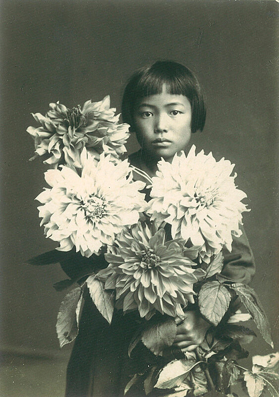 Portrait of Yayoi Kusama at age ten, holding flowers.