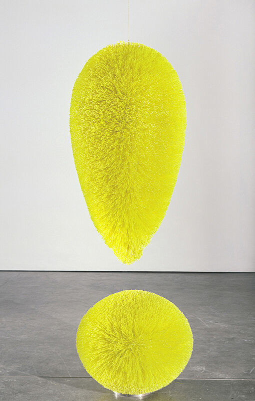 Large, neon-yellow exclamation point sculpture made from plastic bristles. 