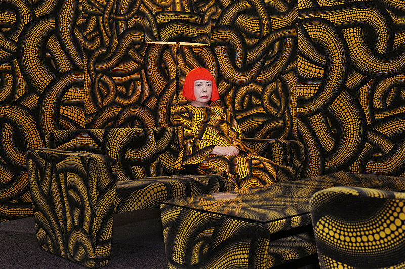 Woman sitting in room covered in pattern.