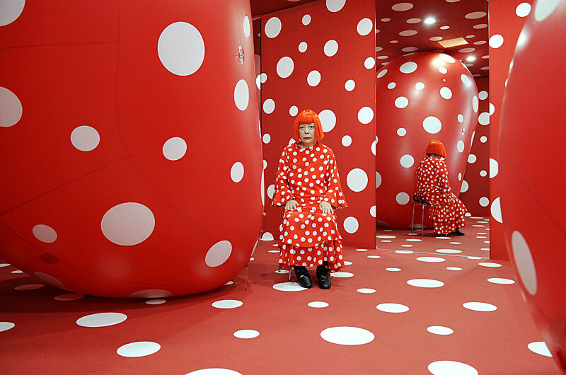 Woman in red room with white dots.