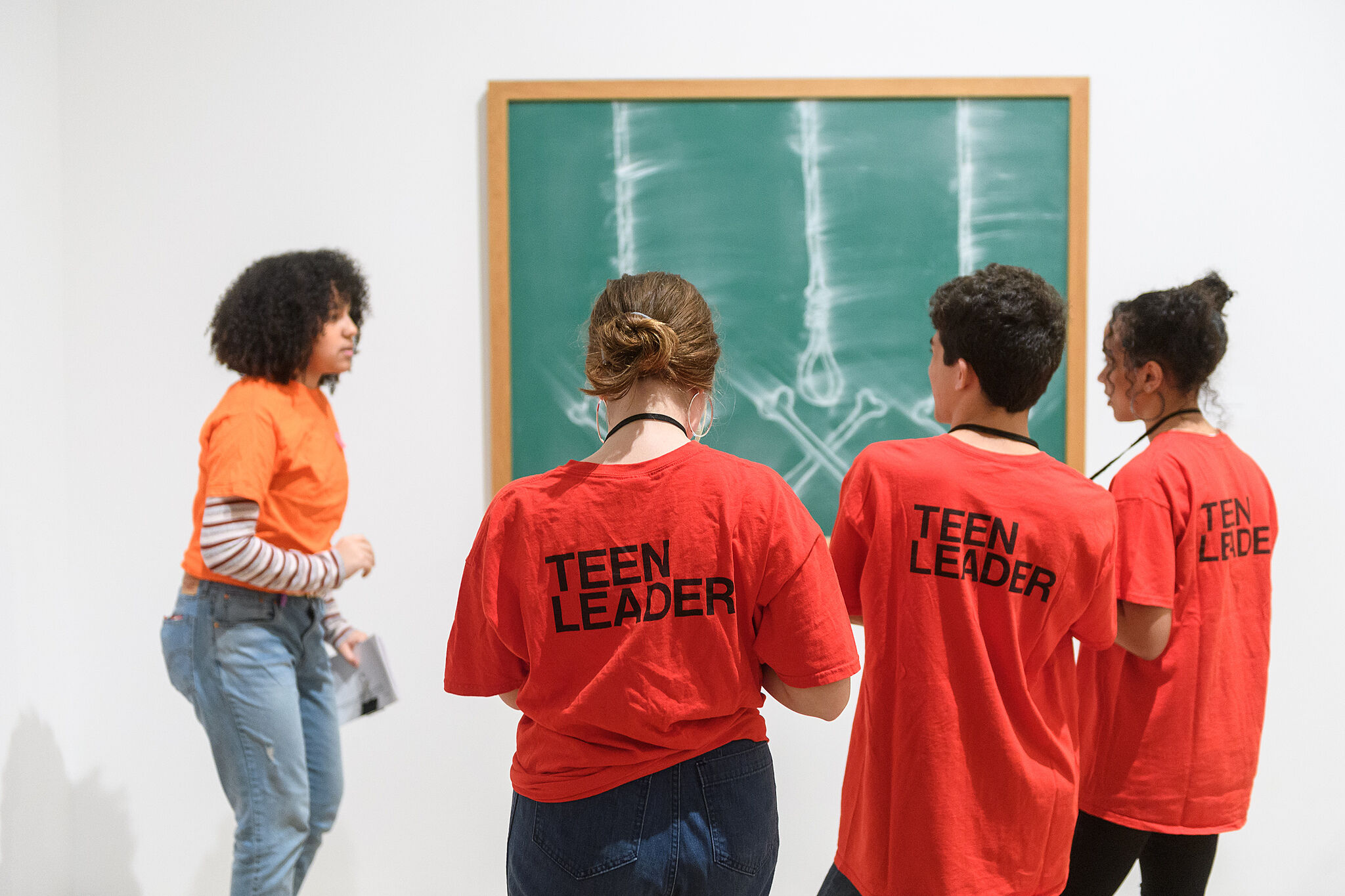 Teen leaders in front of art piece.