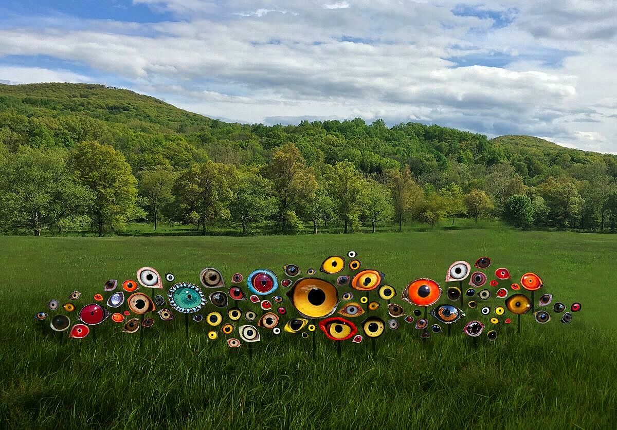 Sculpture of eyes in a grass field.