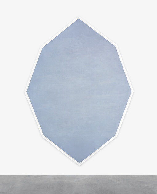 Octagonal blue artwork hanging on a white wall.