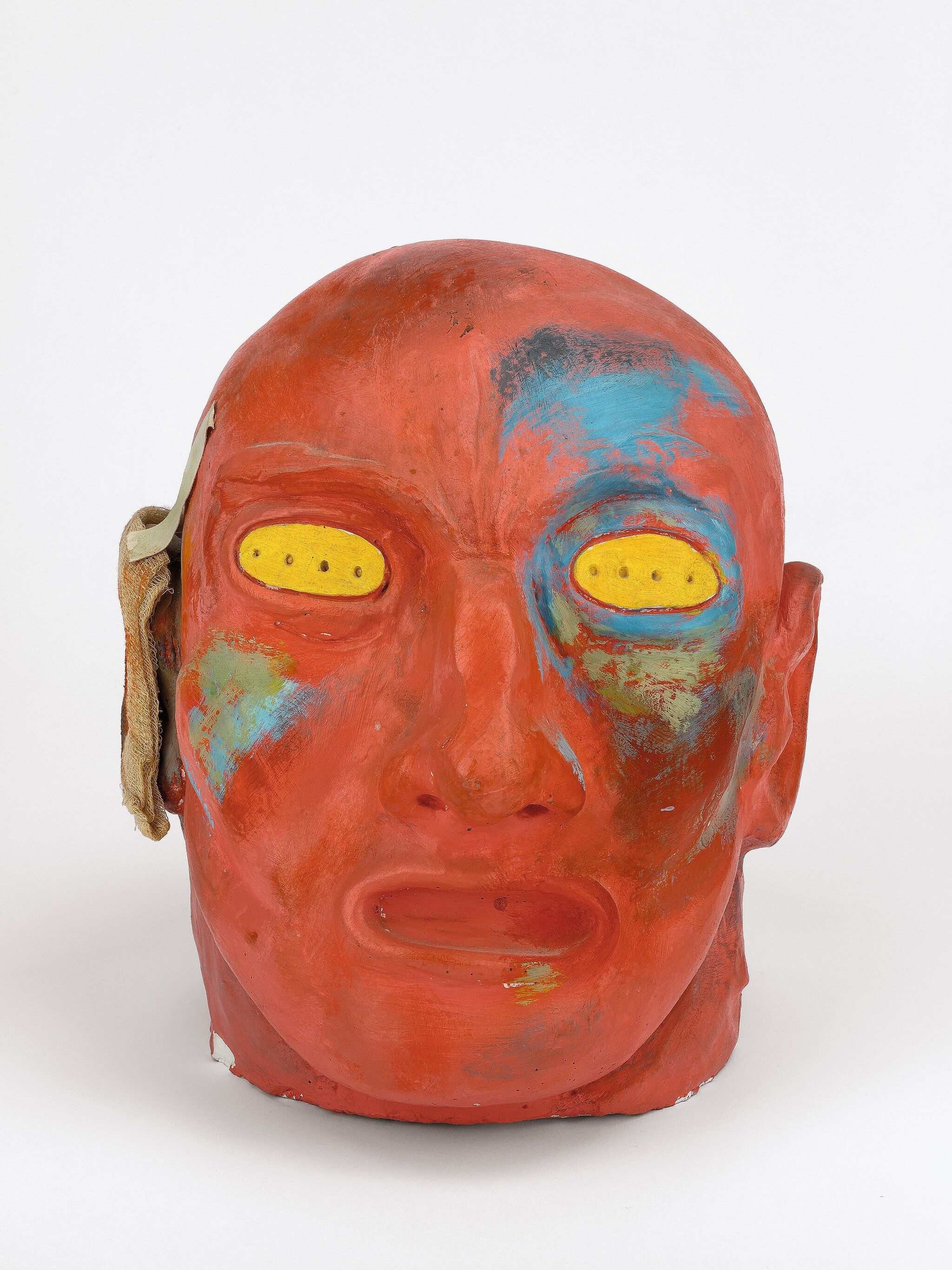 Head painted in colors with yellow eyes.