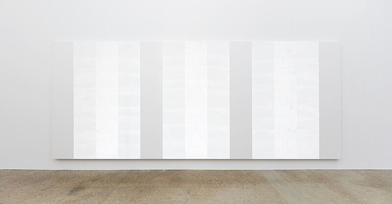 Three white paintings on a wall.