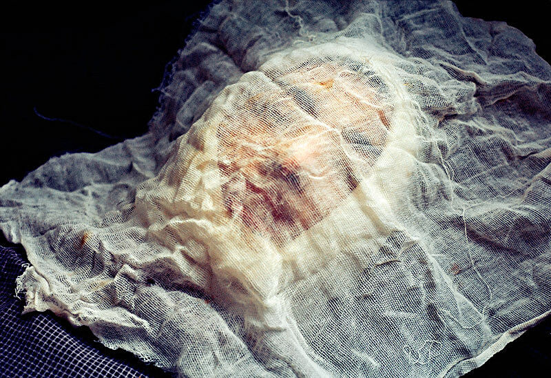 A person lying on the floor with a cloth covering the face. 