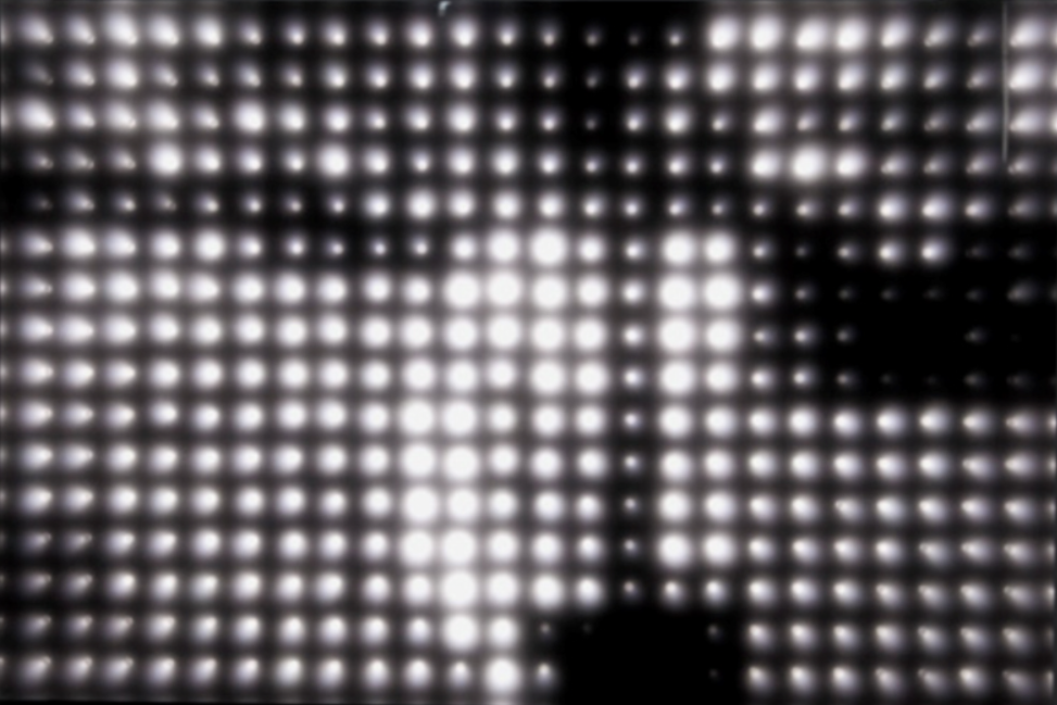 White lights on black background in grid.