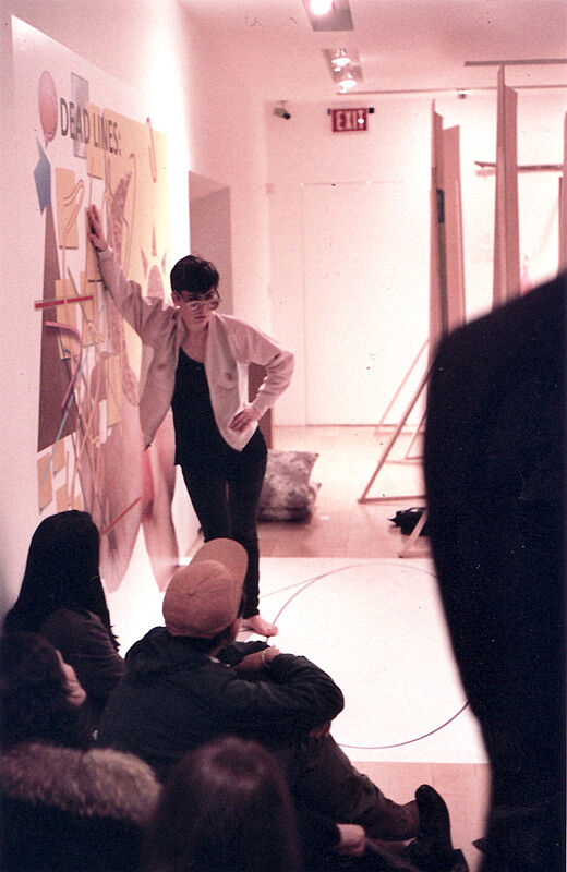 A person leaning against the wall in front a group of people. 