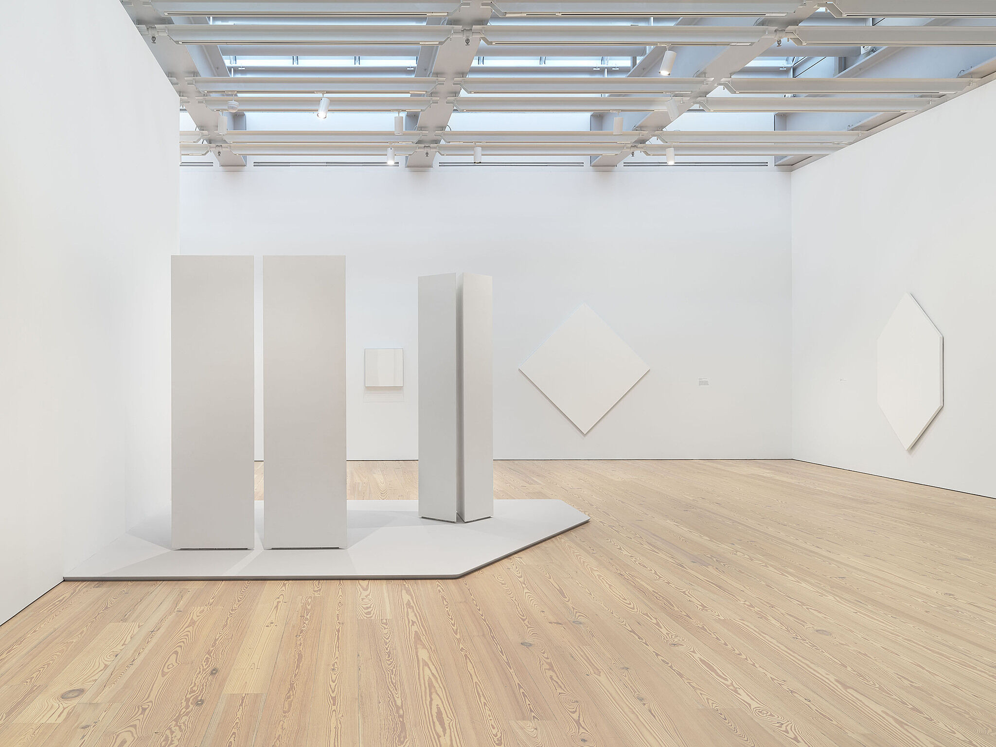 A photo of the installation process for Mary Corse: A Survey in Light
