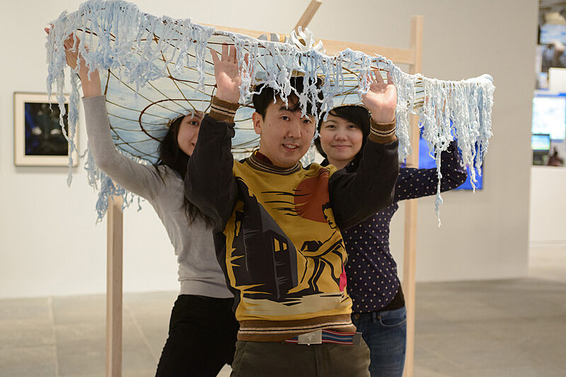 Three people wearing decorated hats. 