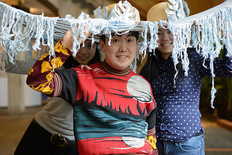 Three people wearing decorated hats. 