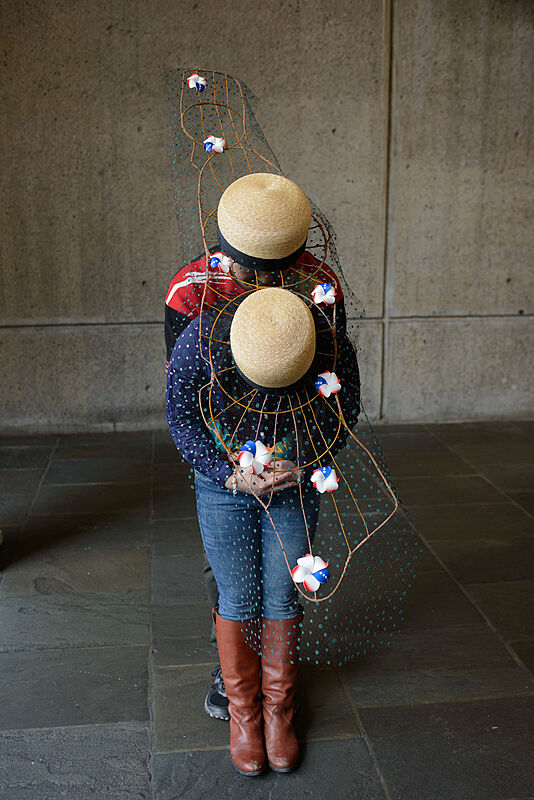 Two people wearing decorated hats. 