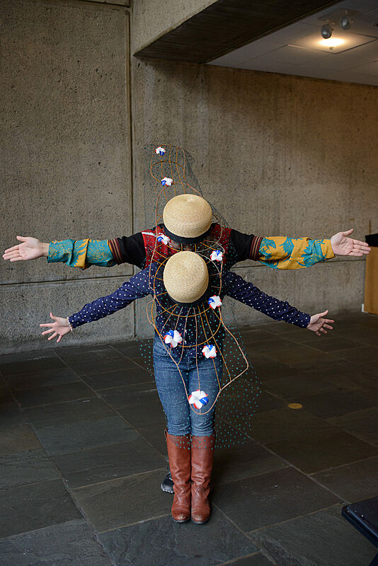 Two people wearing decorated hats. 