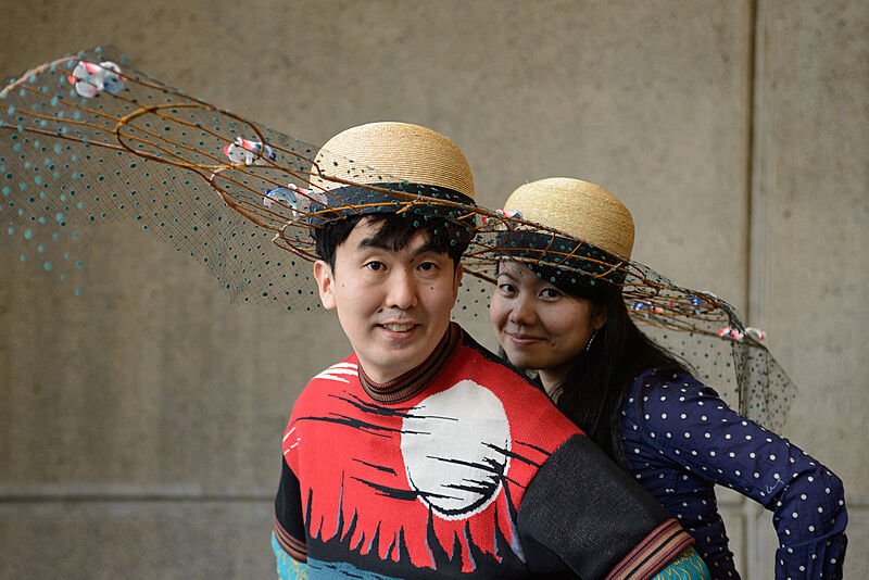 Two people wearing decorated hats. 